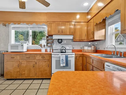 a kitchen with stainless steel appliances a sink window and cabinets
