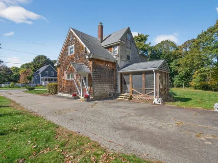 a view of a house with a yard and large tree