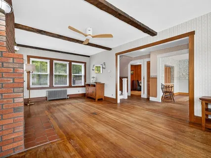 a view of a livingroom with wooden floor and furniture