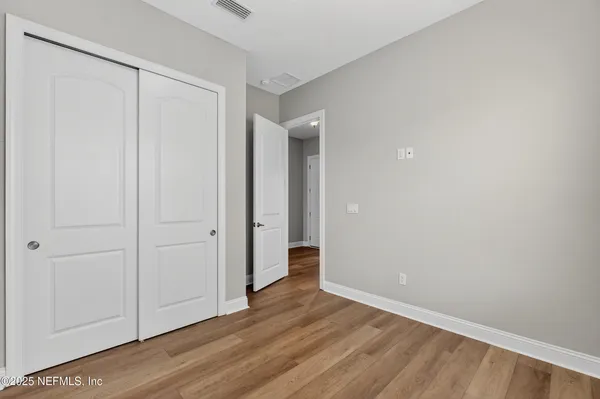 a view of an empty room with a window and fireplace