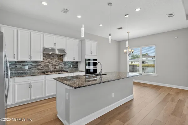 a bathroom with a granite countertop sink toilet a mirror and a window