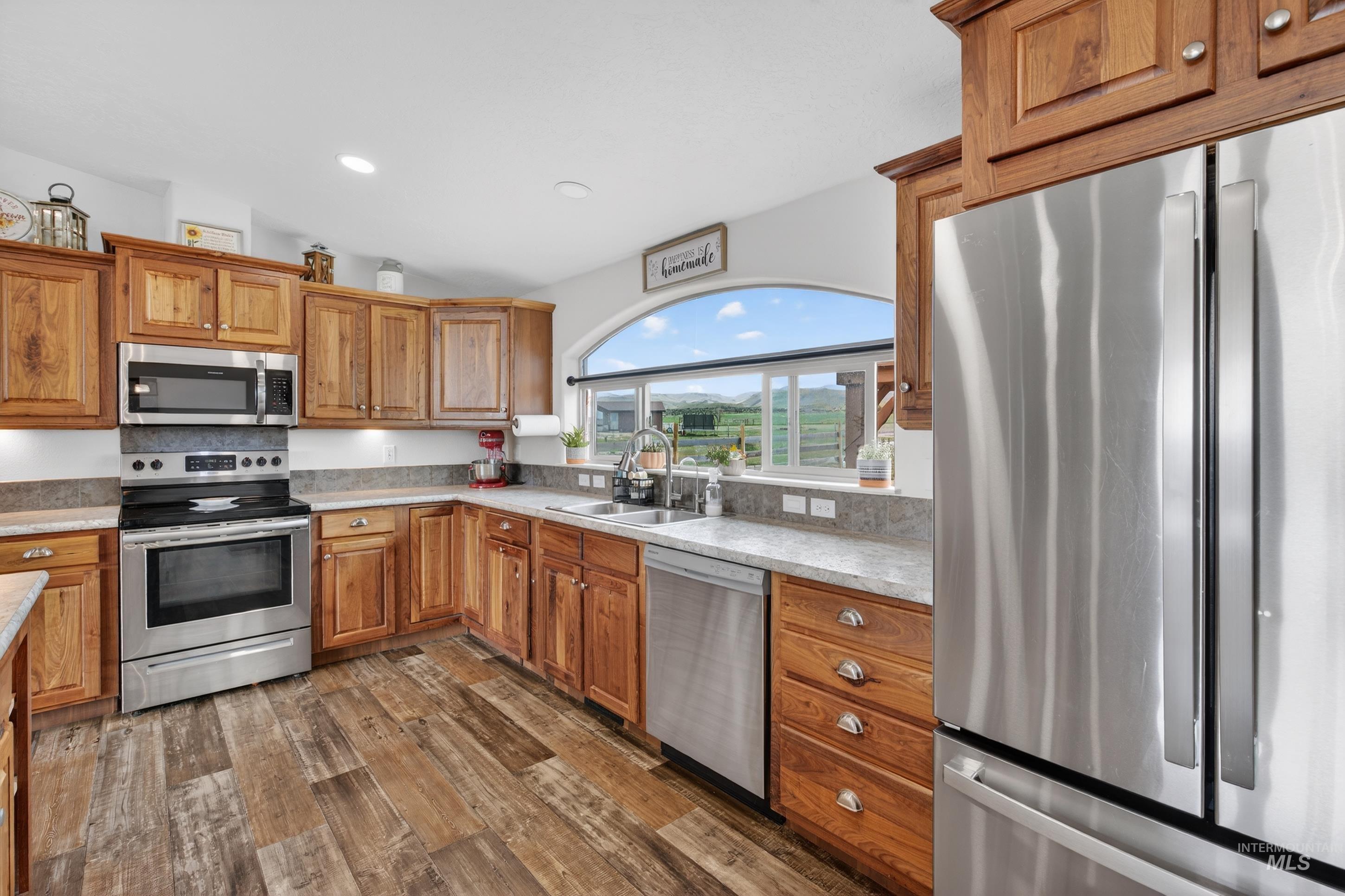 728 Chase Lane Melba, ID 83641 - Photo 16 of 48 Kitchen with stainless steel appliances, wood finish cabinets, dark wood finished floors, lofted ceiling, and recessed lighting
