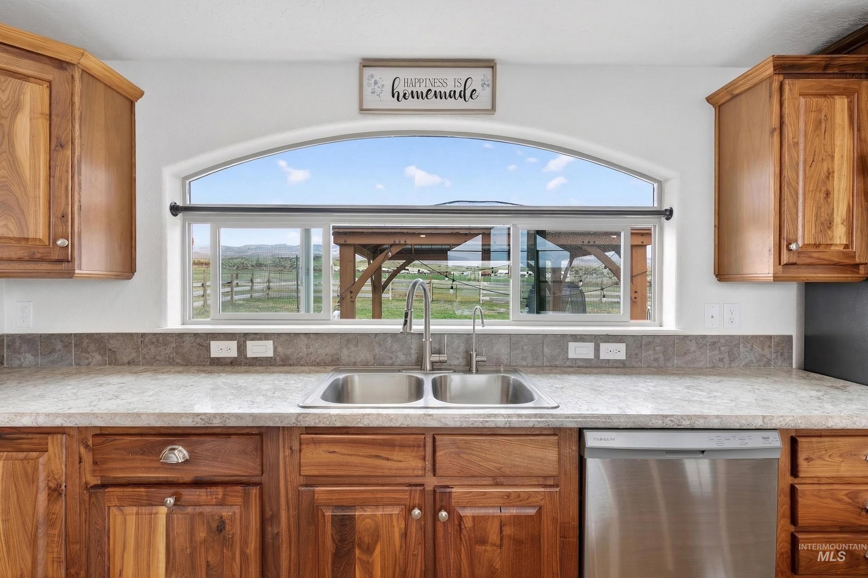 728 Chase Lane Melba, ID 83641 - Photo 17 of 48 Kitchen with wood finish cabinets, dishwasher, light countertops, and healthy amount of natural light
