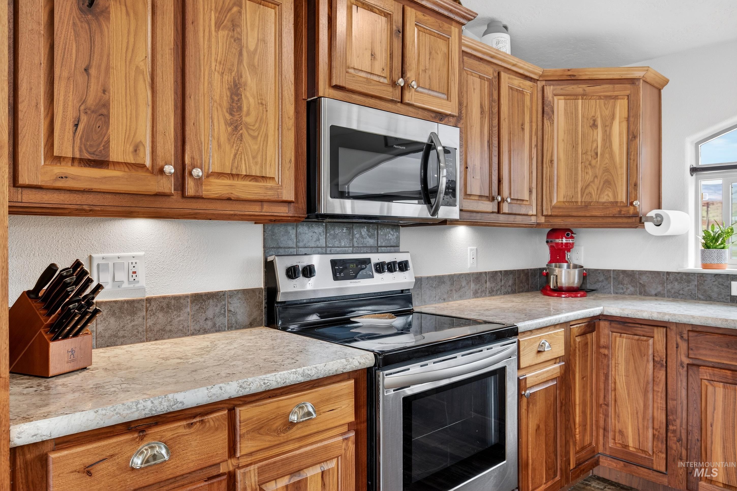 728 Chase Lane Melba, ID 83641 - Photo 19 of 48 Kitchen with stainless steel appliances, light countertops, wood finish cabinets, and a textured wall