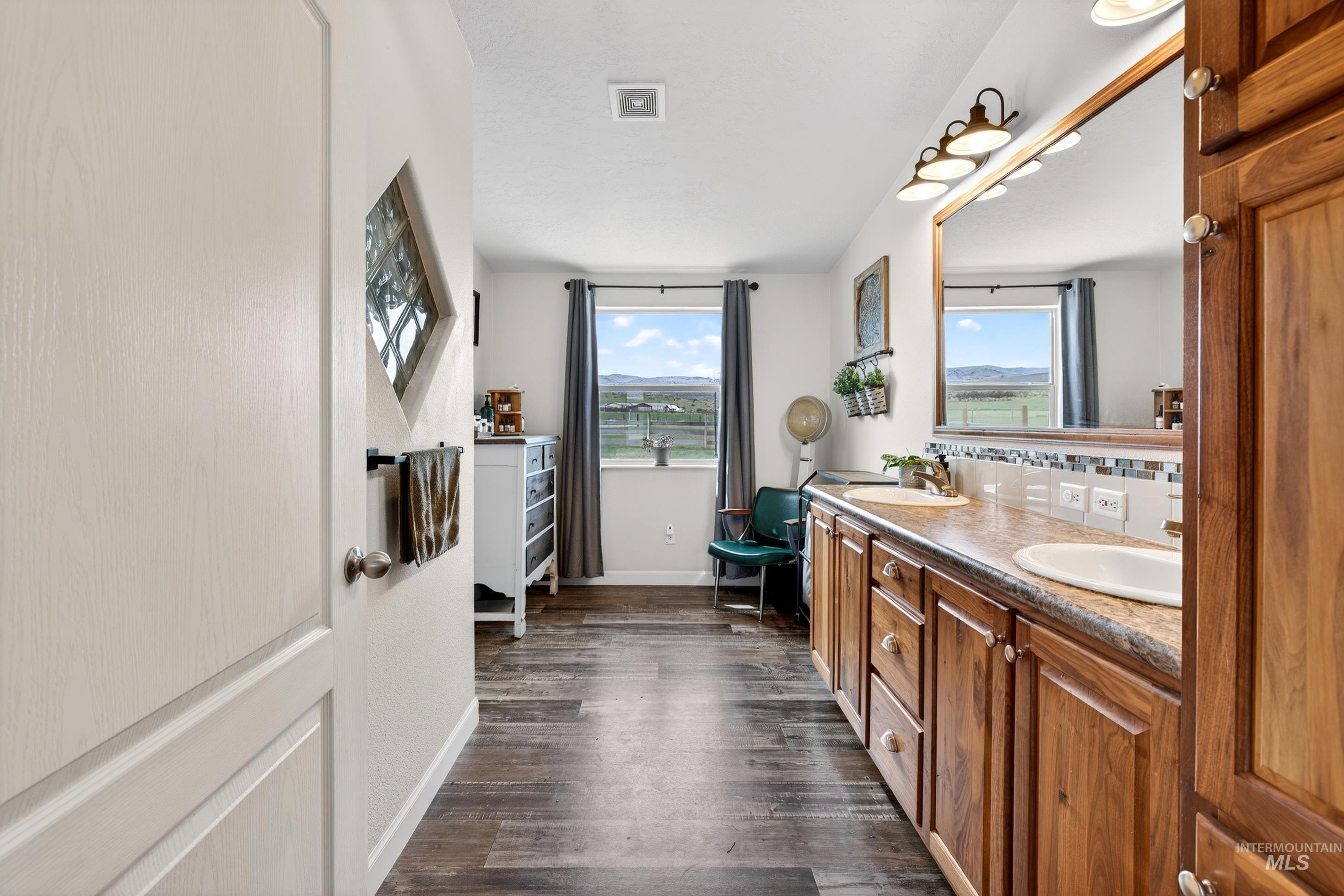 728 Chase Lane Melba, ID 83641 - Photo 24 of 48 Full bath featuring double vanity, plenty of natural light, and dark wood-style flooring