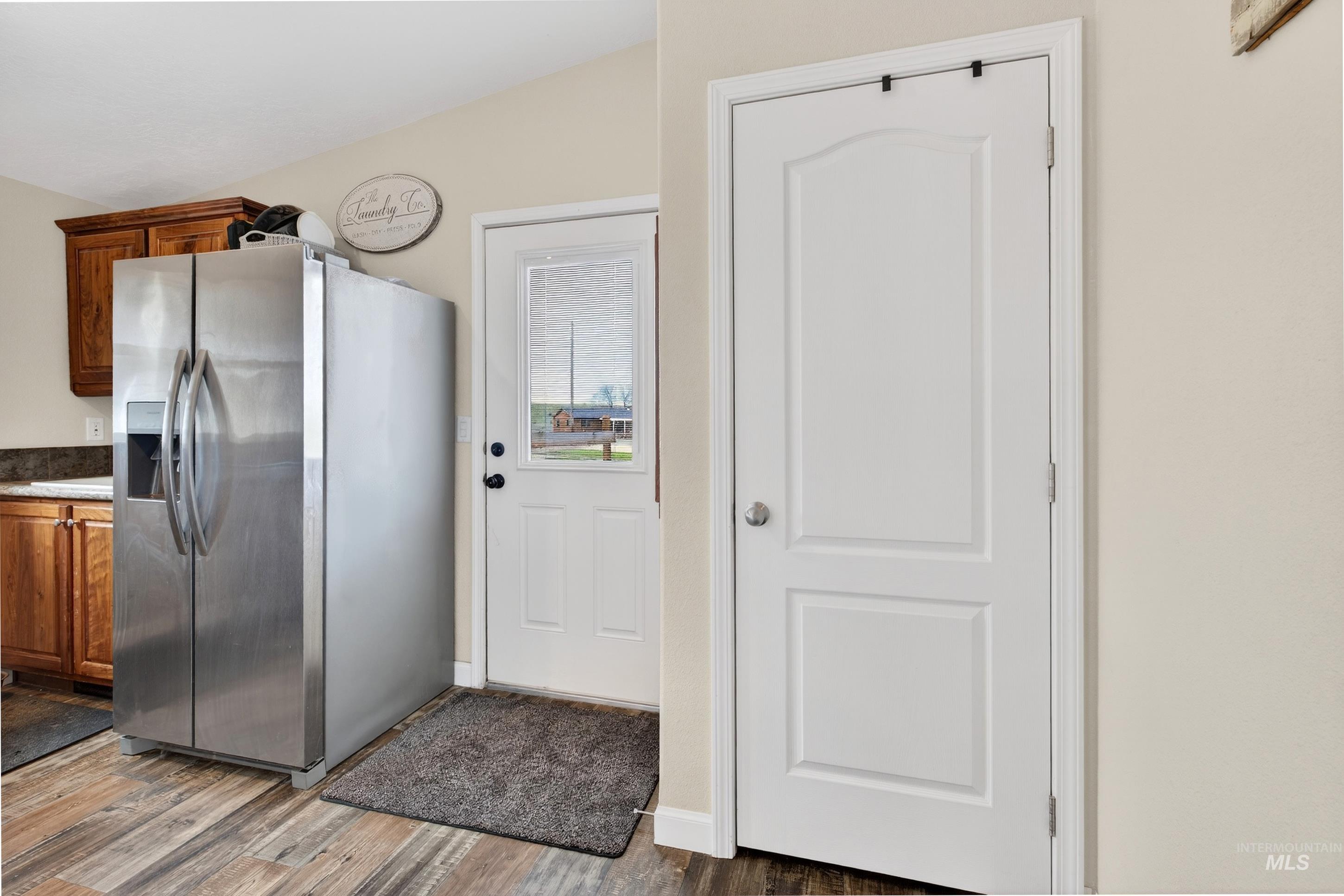 728 Chase Lane Melba, ID 83641 - Photo 33 of 48 Kitchen with stainless steel refrigerator with ice dispenser, light wood-style flooring, wood finish cabinetry, and stone countertops