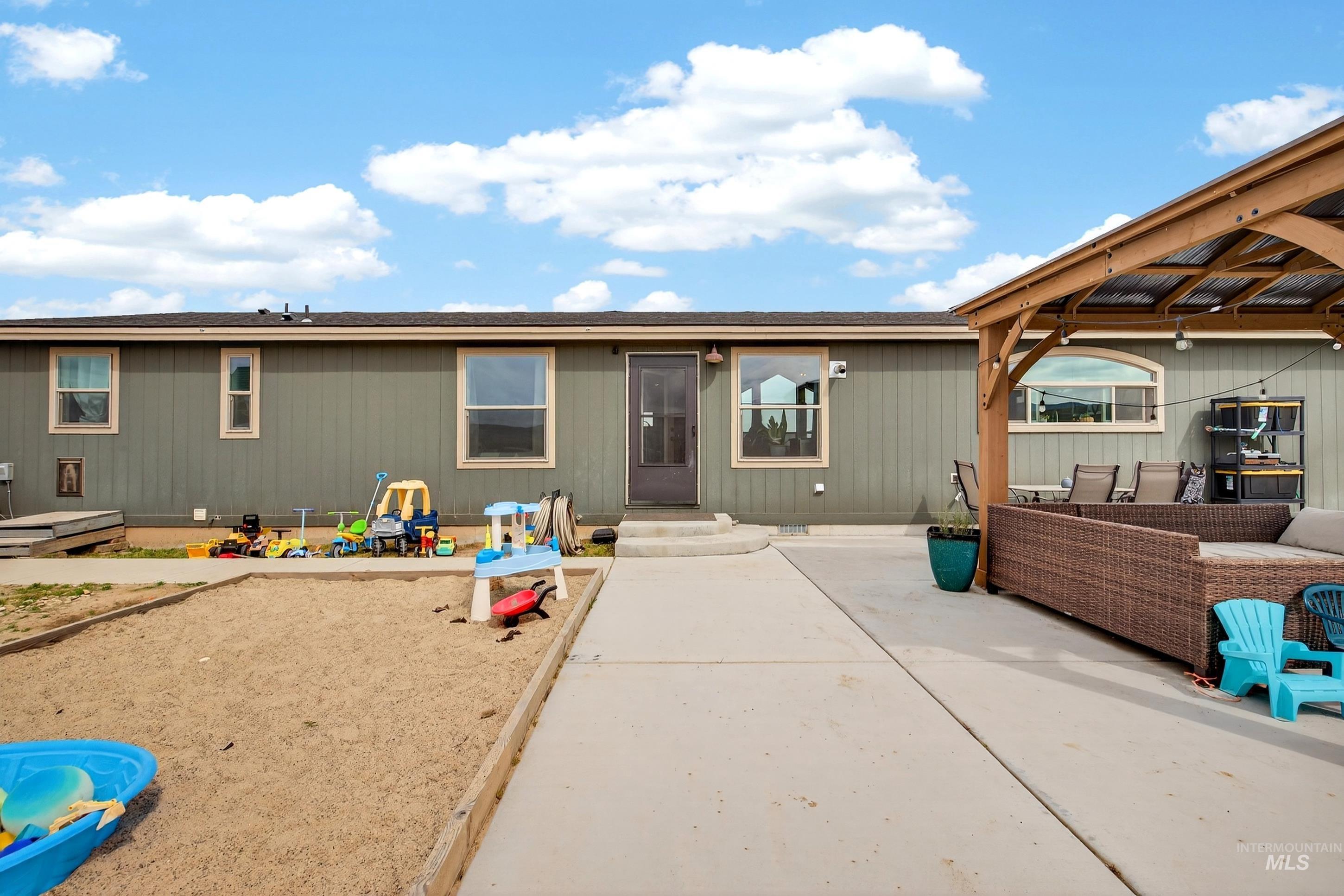 728 Chase Lane Melba, ID 83641 - Photo 35 of 48 Back of house with a patio, a shingled roof, outdoor lounge area, and entry steps