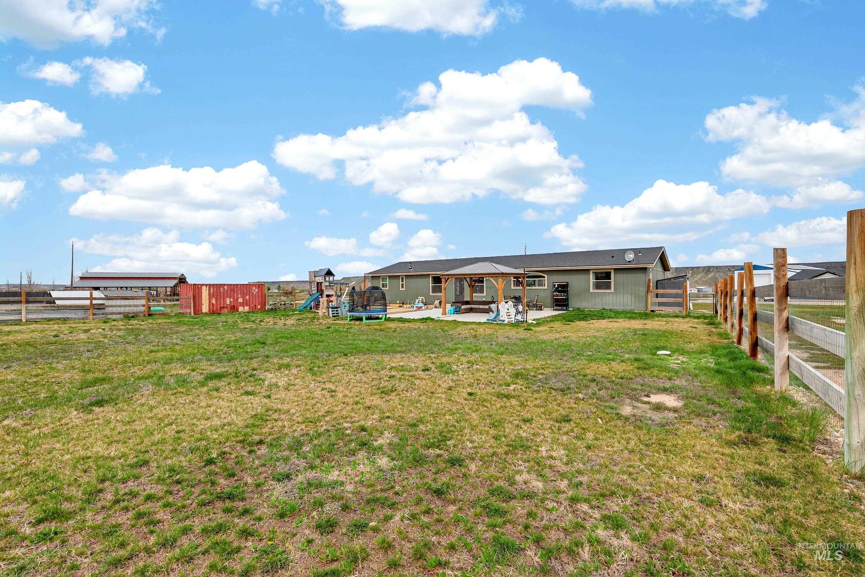 728 Chase Lane Melba, ID 83641 - Photo 39 of 48 Back of property with a patio area, a gazebo, a fenced backyard, and a playground