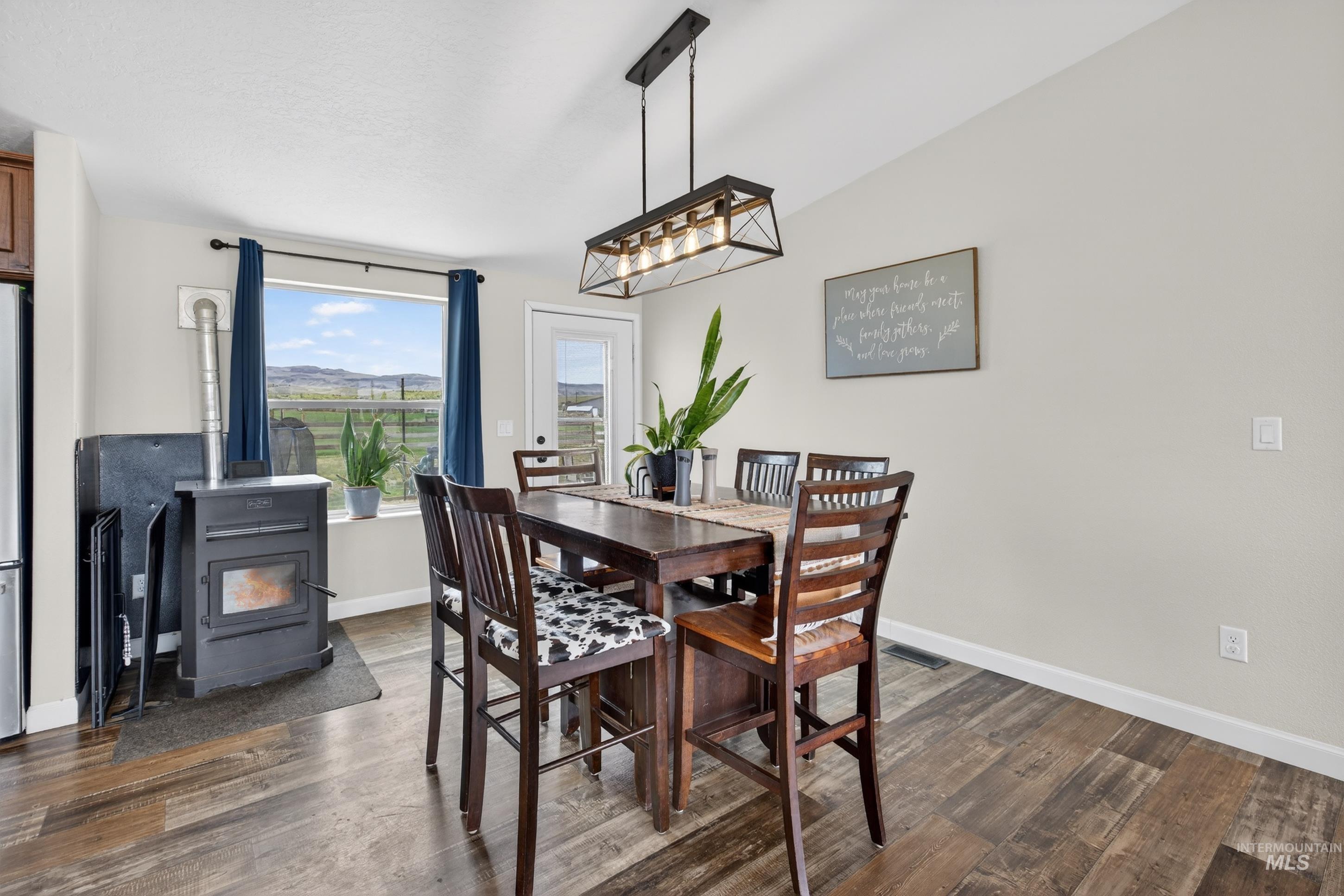 728 Chase Lane Melba, ID 83641 - Photo 10 of 48 Dining area featuring a wood stove and dark wood-style floors