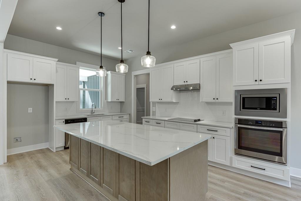 115 Rains Road Jefferson, GA 30549 - Photo 11 of 41 a large kitchen with kitchen island a stove a sink a center island and cabinets