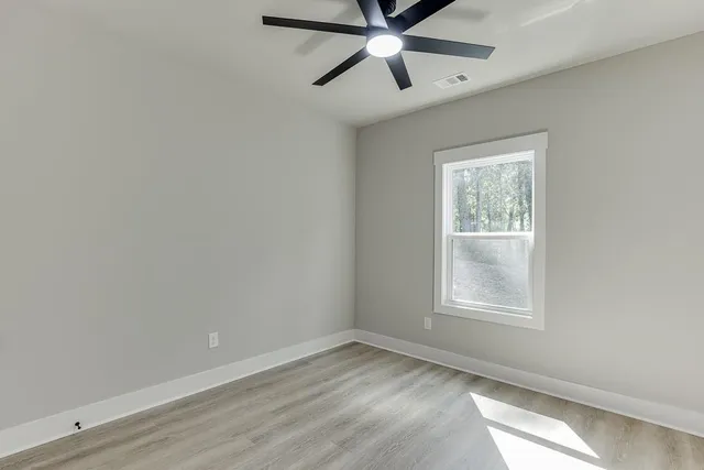 an empty room with a window and a fan