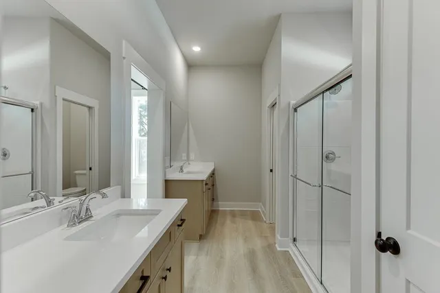 a bathroom with a double vanity sink mirror and shower