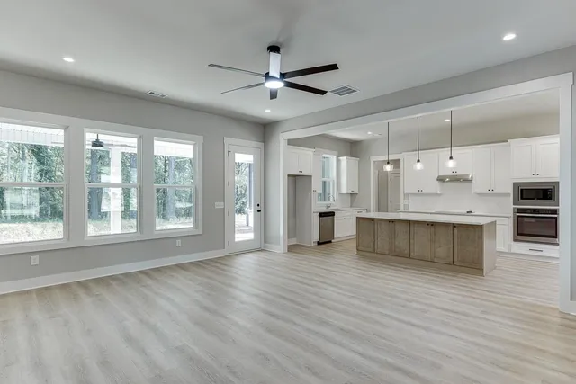 a view of an empty room with kitchen appliances and a window