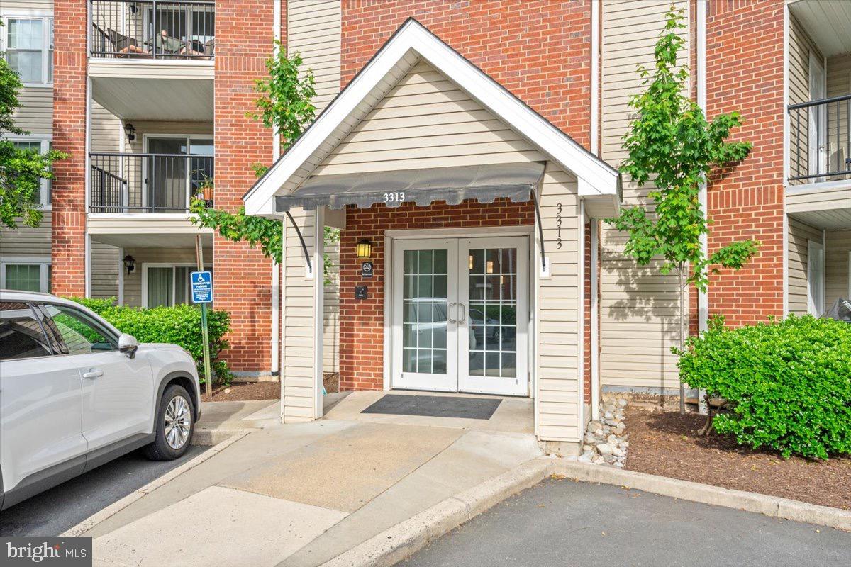 a view of a white car parked in front of a brick house