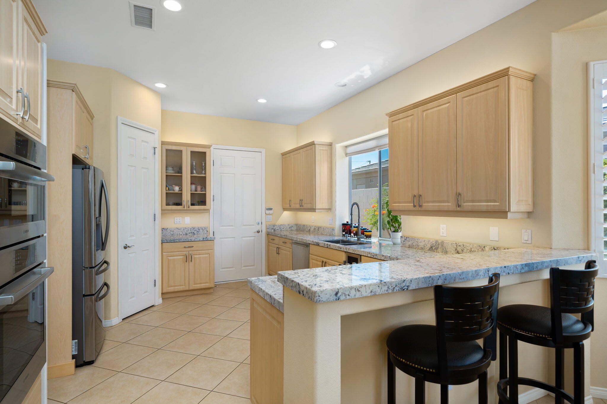 5 Lyon Road Rancho Mirage, CA 92270 - Photo 23 of 50 a kitchen with granite countertop a sink cabinets and refrigerator