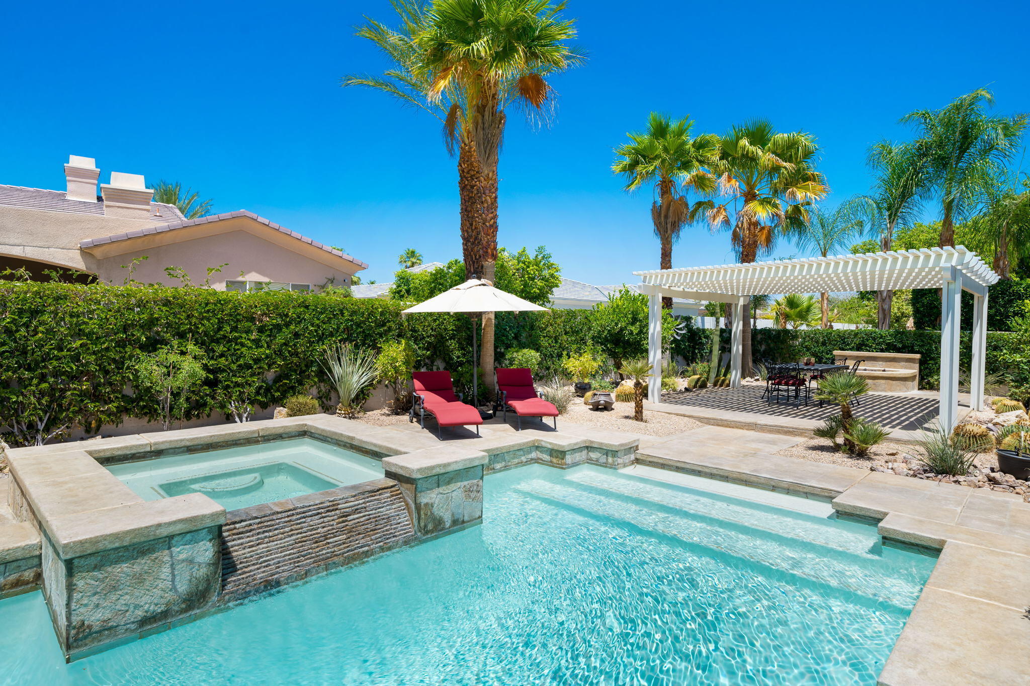 5 Lyon Road Rancho Mirage, CA 92270 - Photo 33 of 50 a view of a backyard with a patio table and chairs under an umbrella