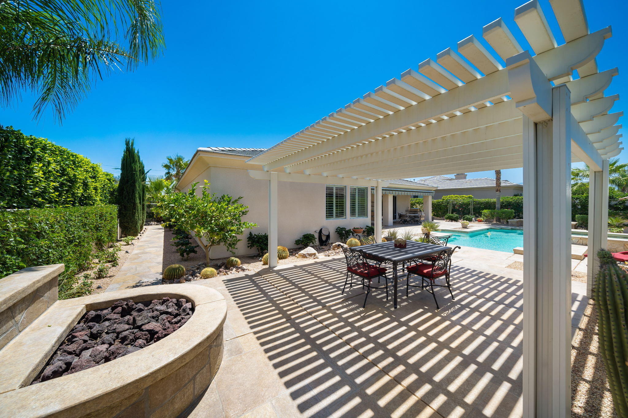 5 Lyon Road Rancho Mirage, CA 92270 - Photo 37 of 50 a view of a patio with a dining table and chairs with wooden floor