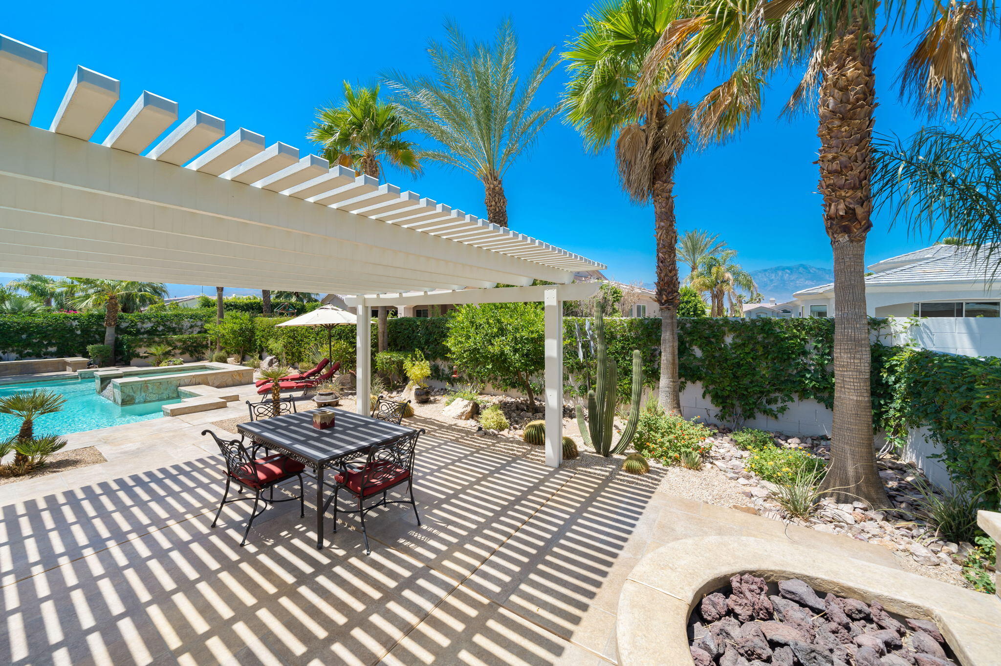 5 Lyon Road Rancho Mirage, CA 92270 - Photo 38 of 50 a view of a patio with table and chairs potted plants and palm trees