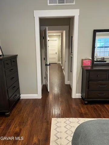 a view of a hallway with wooden floor and furniture