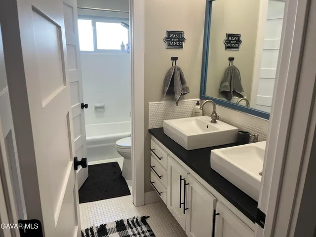 a bathroom with a double vanity sink and a mirror