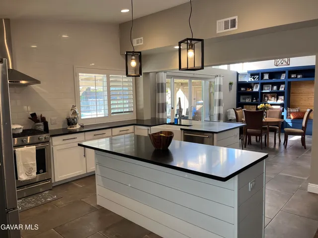 a kitchen with stainless steel appliances granite countertop a sink a stove and a refrigerator