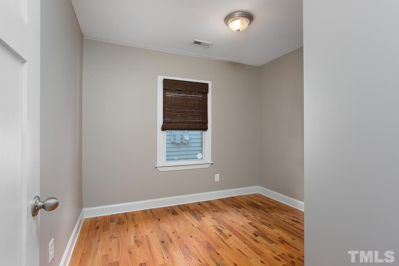 818 Ellington Street Raleigh, NC 27601 - Photo 14 of 20 an empty room with wooden floor and windows
