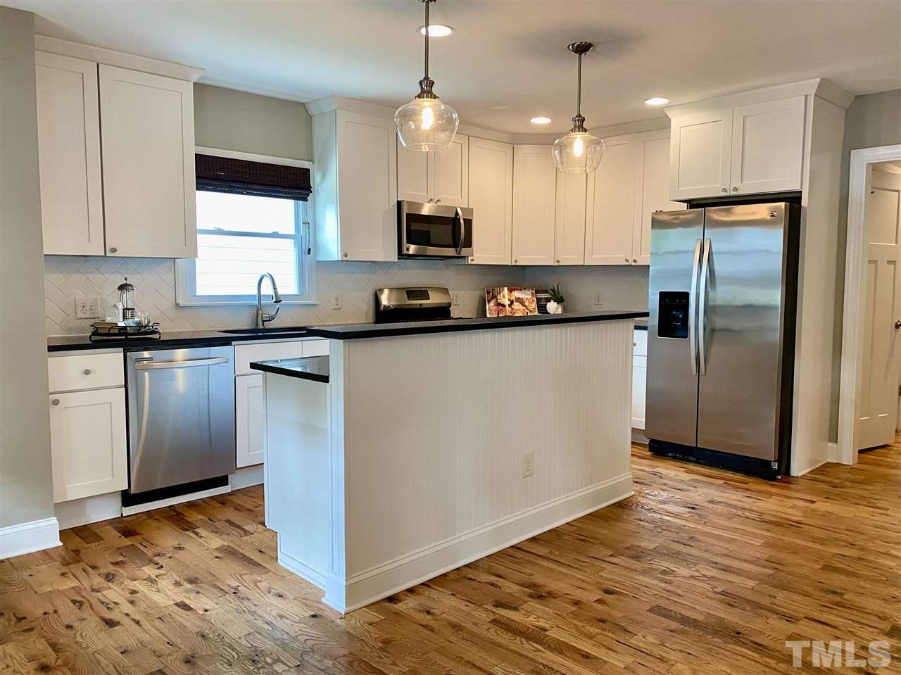 818 Ellington Street Raleigh, NC 27601 - Photo 3 of 20 a kitchen with stainless steel appliances granite countertop a refrigerator a sink a stove and oven