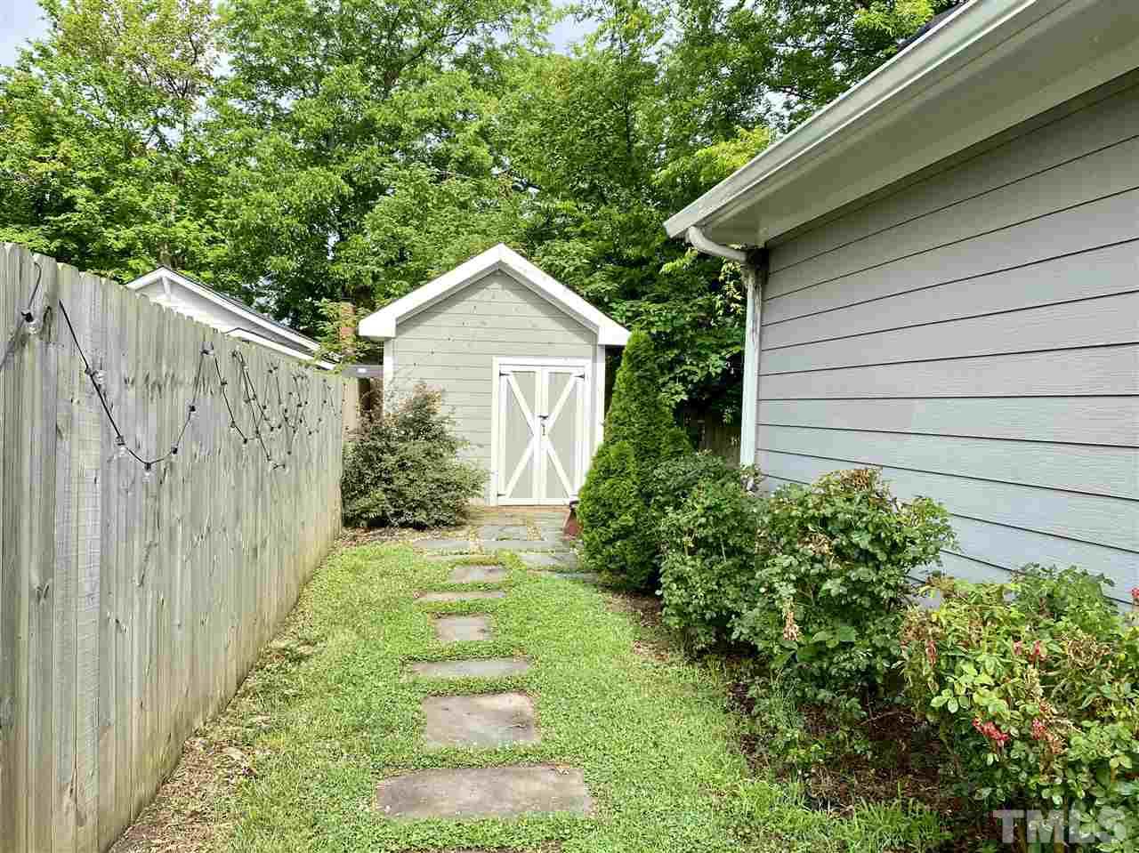 818 Ellington Street Raleigh, NC 27601 - Photo 7 of 20 a view of a house with a small yard plants and large tree