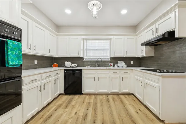 a kitchen with granite countertop a sink stainless steel appliances and cabinets
