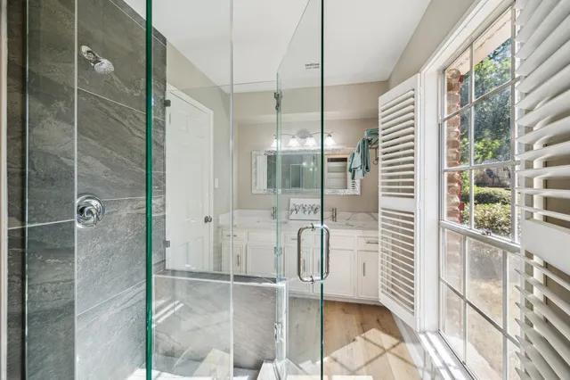 a bathroom with a glass shower door and a glass door