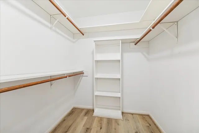 a view of walk in closet with empty racks
