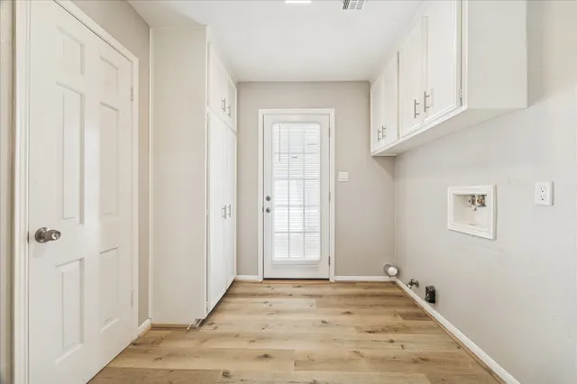 a view of an empty room with cabinet and window