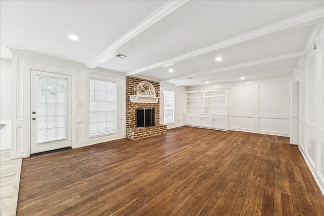 a view of empty room with wooden floor and fireplace