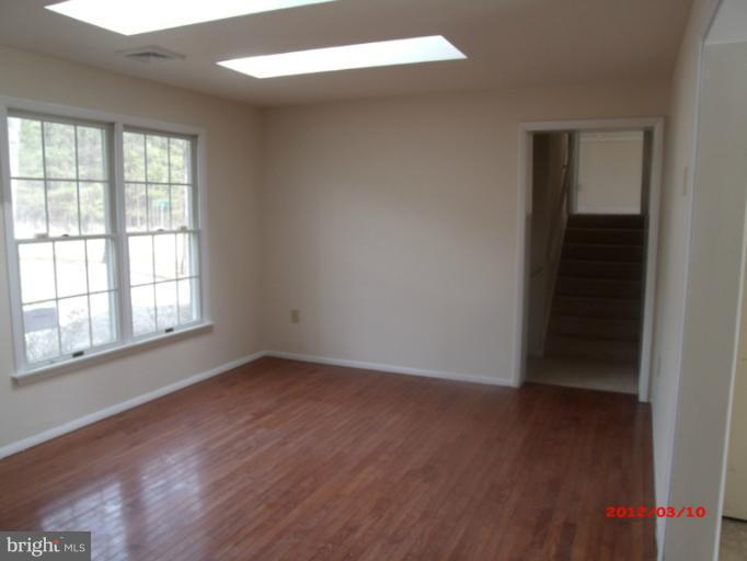 710 Planters Wharf Road Lusby, MD 20657 - Photo 11 of 16 an empty room with wooden floor and windows