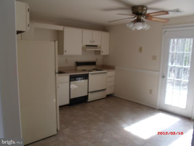 710 Planters Wharf Road Lusby, MD 20657 - Photo 4 of 16 a kitchen with stainless steel appliances a sink a stove a refrigerator cabinets and a window