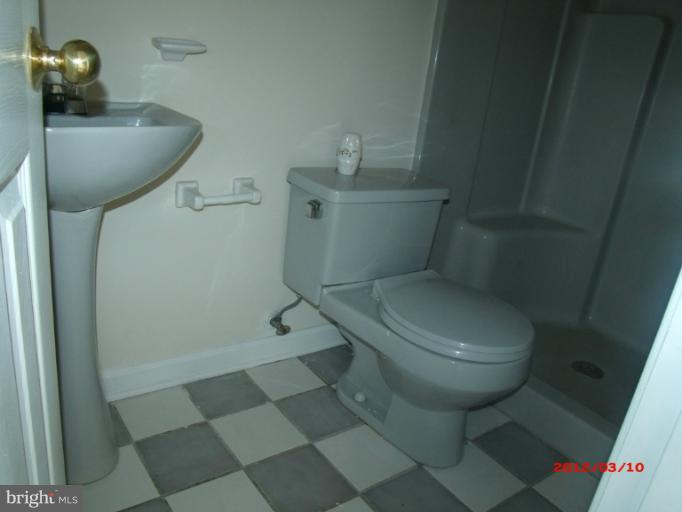 710 Planters Wharf Road Lusby, MD 20657 - Photo 9 of 16 a white toilet sitting next to a bathroom sink and vanity
