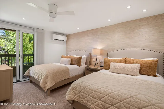 a bedroom with two beds and a large window