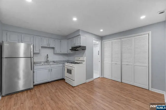 a kitchen with granite countertop stainless steel appliances a refrigerator and a sink