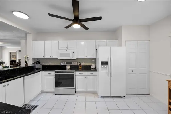 a kitchen with white cabinets and white appliances