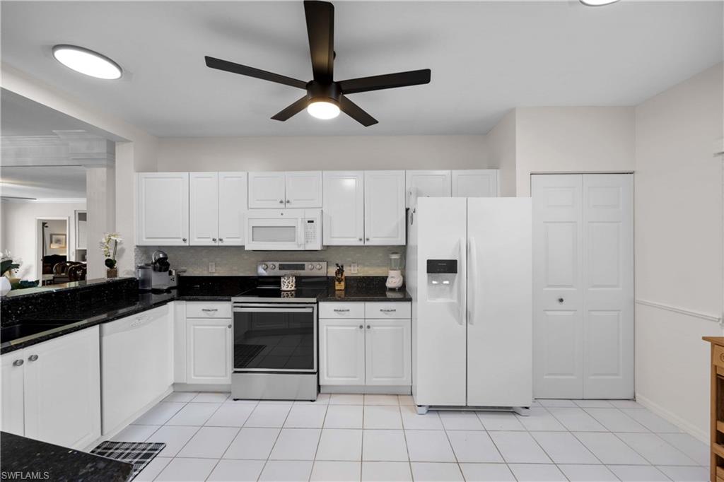 9022 Michael Circle, Unit 1 Naples, FL 34113 - Photo 11 of 29 a kitchen with white cabinets and white appliances