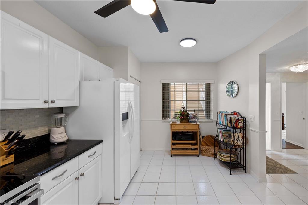 9022 Michael Circle, Unit 1 Naples, FL 34113 - Photo 12 of 29 a kitchen with stainless steel appliances granite countertop a refrigerator and a stove top oven
