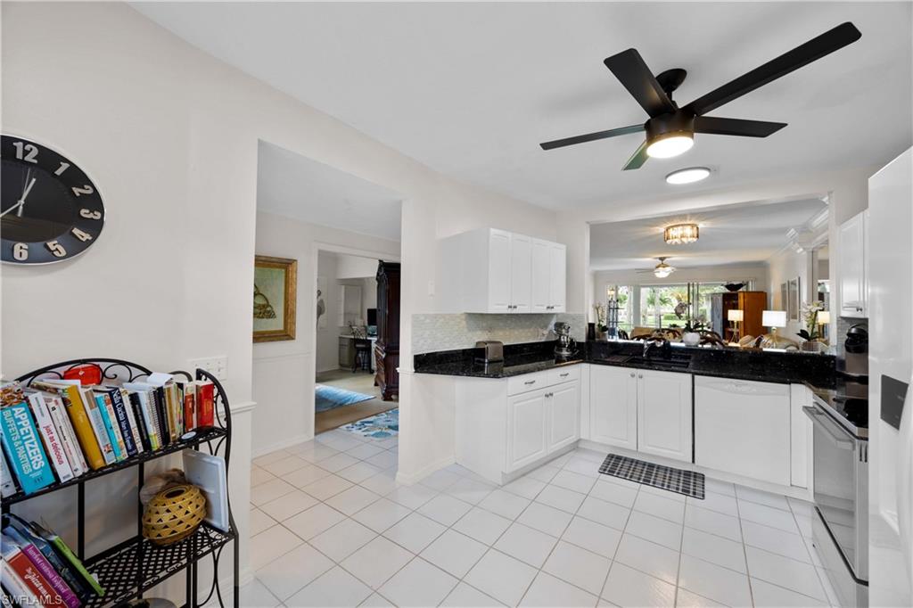 9022 Michael Circle, Unit 1 Naples, FL 34113 - Photo 13 of 29 a kitchen with granite countertop a white refrigerator a sink a stove and white cabinets