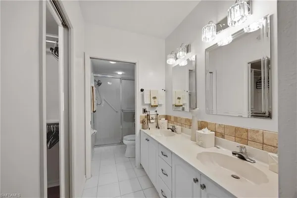 a spacious bathroom with a double vanity sink mirror and shower