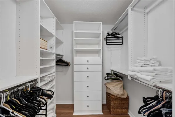 a view of walk in closet with clothes and shoes