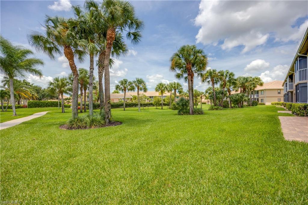 9022 Michael Circle, Unit 1 Naples, FL 34113 - Photo 26 of 29 a view of a yard with a fountain and a palm tree