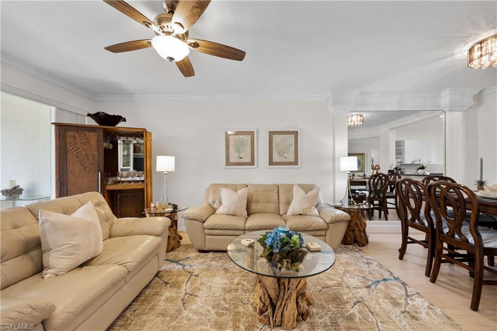 9022 Michael Circle, Unit 1 Naples, FL 34113 - Photo 6 of 29 a living room with furniture kitchen view and a chandelier
