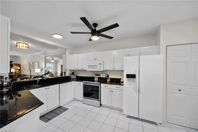 a kitchen with white cabinets and appliances