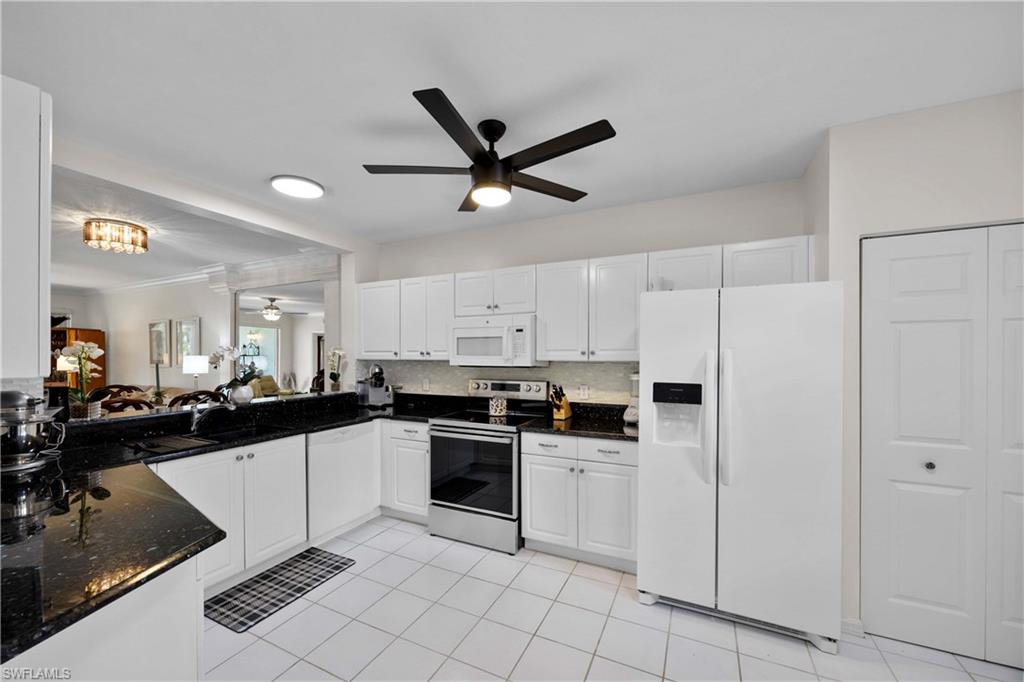 9022 Michael Circle, Unit 1 Naples, FL 34113 - Photo 10 of 29 a kitchen with white cabinets and appliances