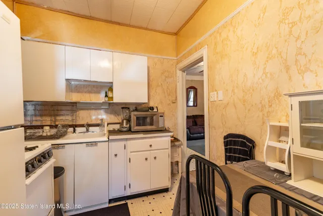 a kitchen with stainless steel appliances granite countertop a stove a sink dishwasher and white cabinets with wooden floor