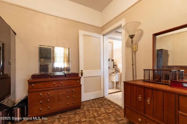 a bedroom with a dresser and a mirror